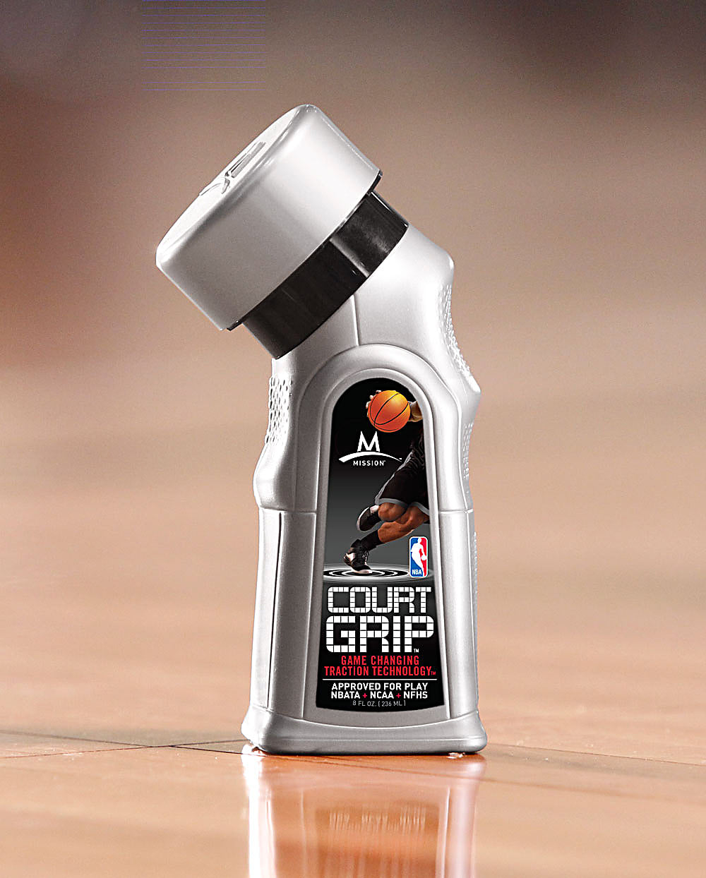 The Court Grip bottle on a hardwood court, cap canted on its collar